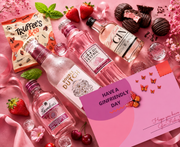Pink gin gift hamper flat lay with gin, mixers and chocolates